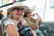 two women sit on an NYC tour bus
